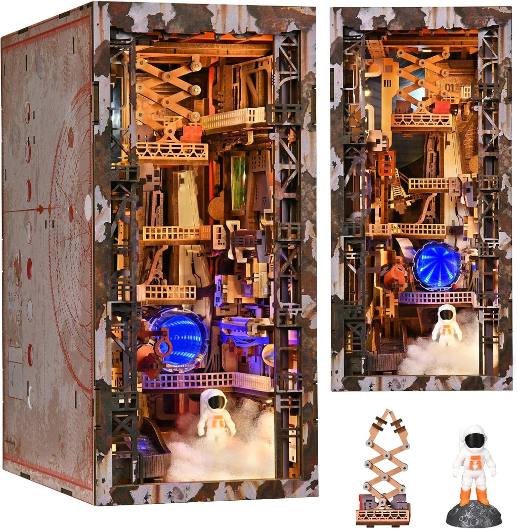 Close-up details of the Aerospace Foundry book nook featuring a miniature astronaut, rocket components, blue illuminated portal and workshop structures