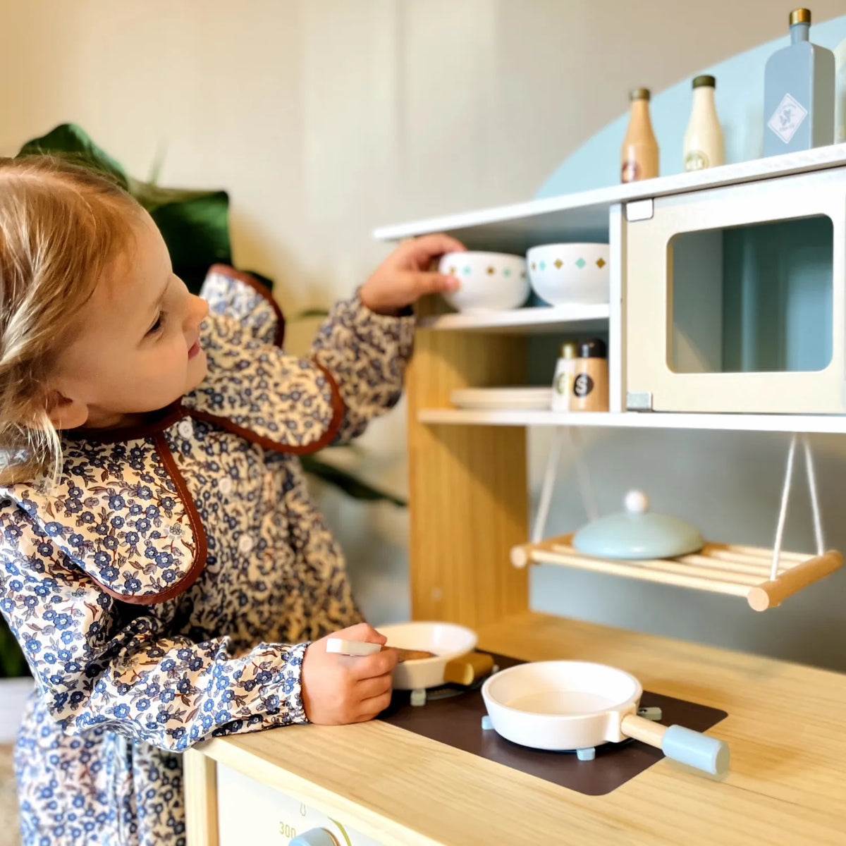ROBUD Dream Wooden Play Kitchen with child organising bowls and preparing pretend food on the stovetop