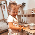 ROBUD Olivia Caramel Kids Play Kitchen with child enjoying pretend cooking using the sink, cookware and wooden kitchen accessoriesROBUD Olivia Caramel Kids Play Kitchen with child enjoying pretend cooking using the sink, cookware and wooden kitchen accessories