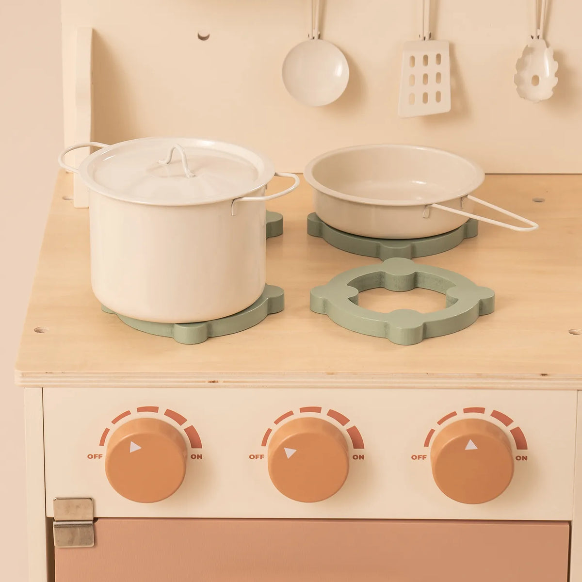 ROBUD Rustic Wooden Kids Play Kitchen close-up showing three rotating stovetop knobs, cookware and wooden cooking accessories