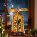ROKR Angel's Christmas Pyramid displayed beside a window with warm lights, a rotating golden top and a miniature Christmas tree surrounded by angels