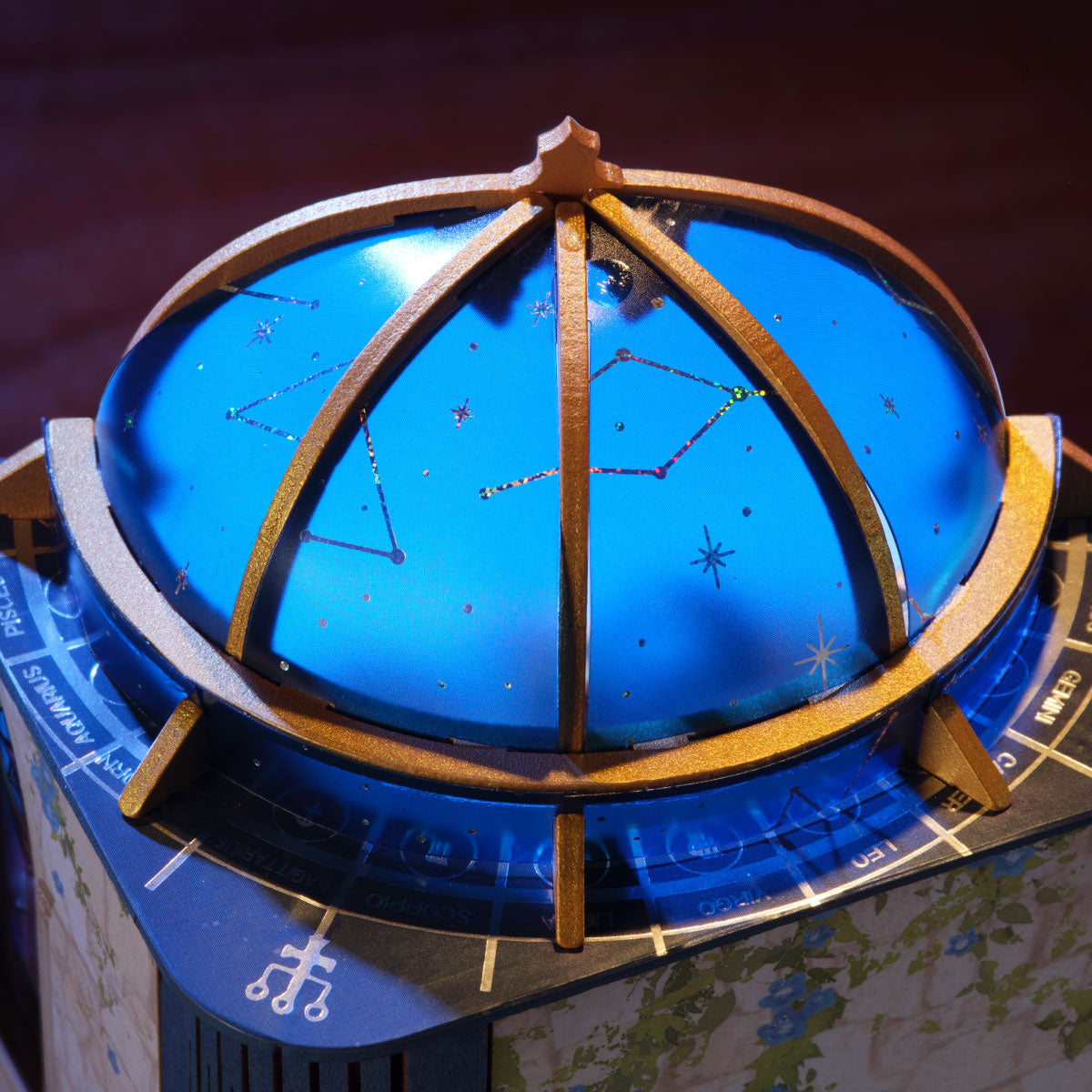 Rolife Astral Dome close-up showing the blue observatory-style dome with a gold frame, constellation patterns, zodiac symbols and celestial markings