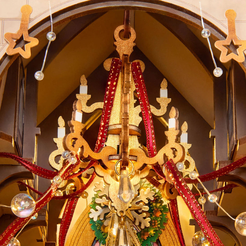 Rolife Caroling Cathedral miniature chandelier decorated with red ribbons, golden candle details, hanging ornaments and a green Christmas wreath