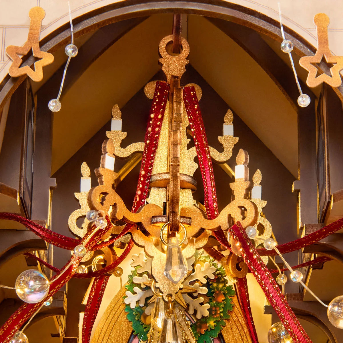 Rolife Caroling Cathedral miniature chandelier decorated with red ribbons, golden candle details, hanging ornaments and a green Christmas wreath