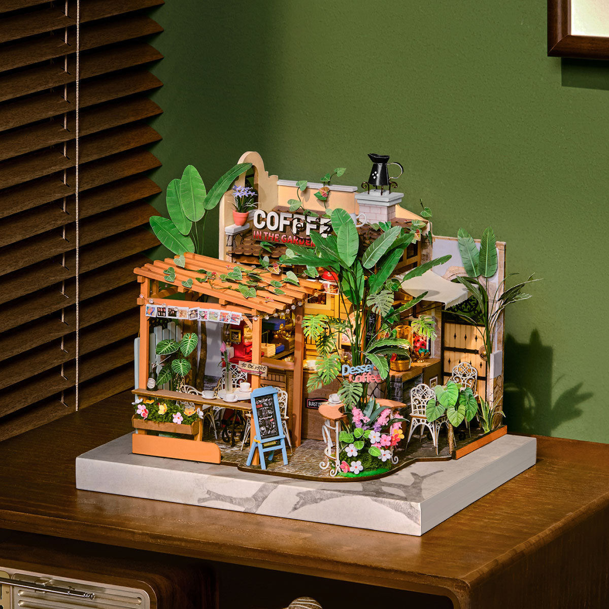 Rolife Leafree Café miniature house displayed on a table with garden café details, outdoor seating and climbing greenery

Voyza