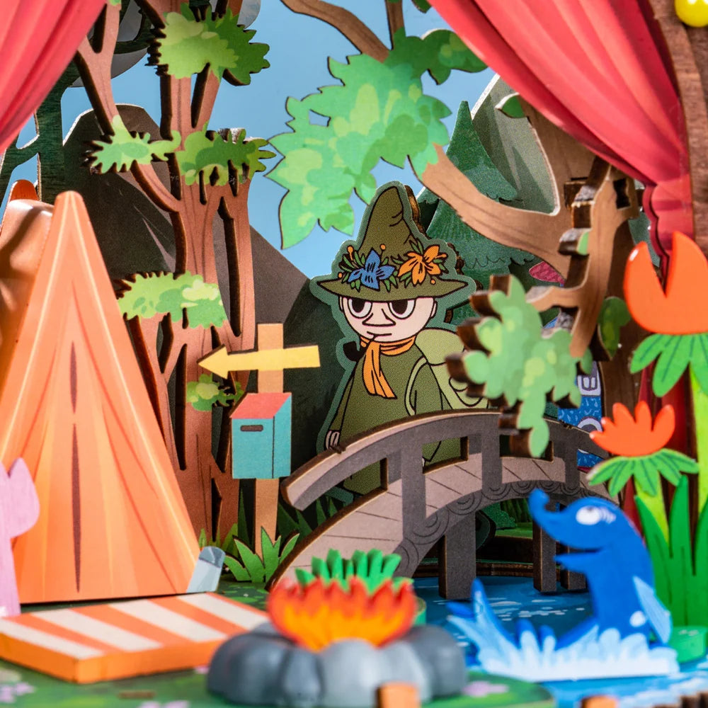 Rolife Moomintroll's Forest Camp close-up of Snufkin standing beside the miniature wooden bridge, forest trees and riverside campfire