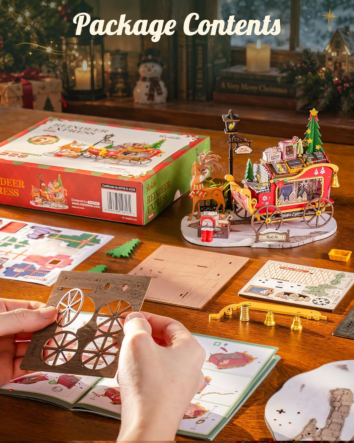 Rolife Reindeer Express DIY miniature house kit contents showing the product box, wooden assembly boards, sleigh wheel components, decorative pieces and illustrated instructions