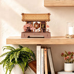Rowood Sacred Sakura Temple miniature Japanese shrine displayed on a wooden shelf above books and beside decorative plants